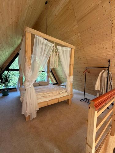 ein Schlafzimmer mit Himmelbett in einer Hütte in der Unterkunft Chalet Green in Cazaci