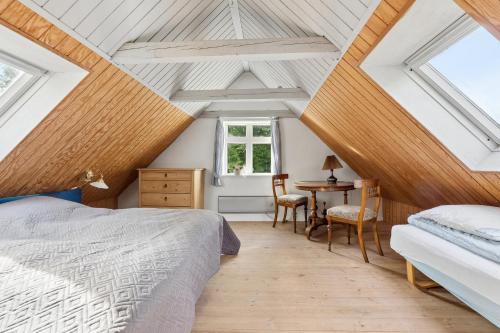 a attic bedroom with a bed and a table at Charming 45 M House In Peaceful Setting in Gelsted