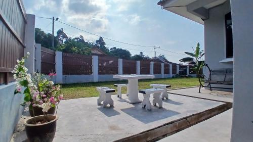 a picnic table and two benches on a patio at Homestay Makyu Kuala Kangsar in Kuala Kangsar