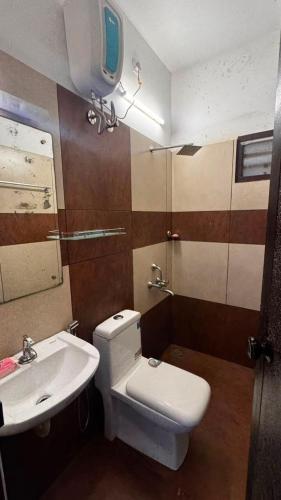 a bathroom with a white toilet and a sink at Urban Escape in Cochin
