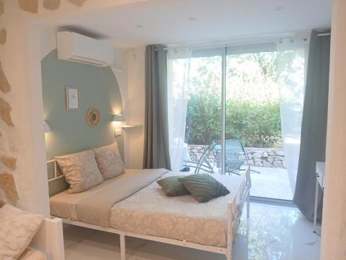 a small bedroom with a bed and a balcony at Studio calme avec terrasse et piscine in Saint-Vallier-de-Thiey