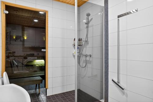 a bathroom with a shower and a sink at Cozy two-room apartment with sauna in Sodankylä