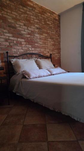 a bed in a room with a brick wall at The Cozy Nest in Santa Maria a Monte