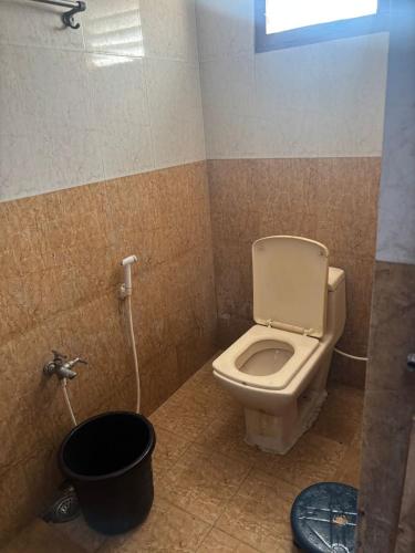 a bathroom with a toilet and a bucket in it at Lara Homestay duplex 3bhk in Secunderabad
