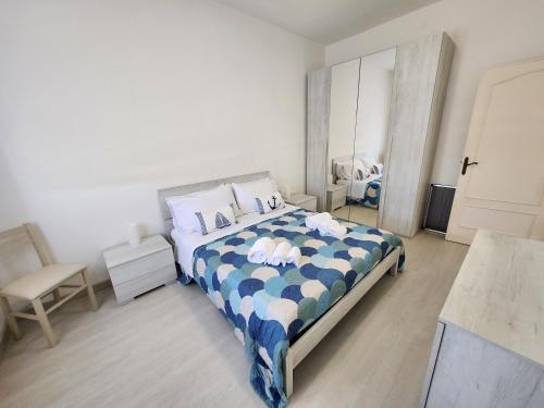 a bedroom with a bed with a blue and white comforter at Casa MedeFaby Due in S'archittu Cuglieri