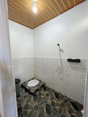 a bathroom with a toilet and a shower at Kaffana Cabin House in Banjarnegara