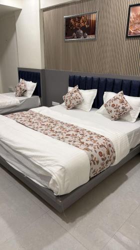 two beds with pillows on them in a bedroom at Hotel Runway in Vadodara