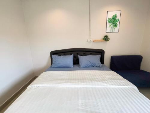 a bed with blue pillows in a room at U Dee Room and Coffee in Kanchanaburi City