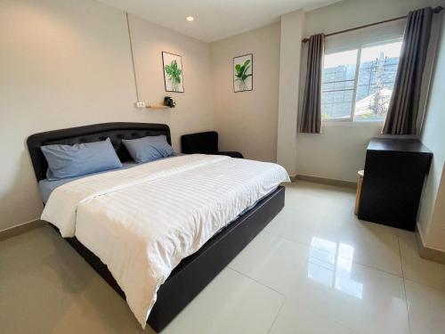 a bedroom with a large bed and a window at U Dee Room and Coffee in Kanchanaburi City