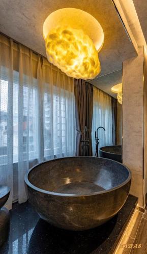 a large stone bath tub in a bathroom at Midas Hotel 2 in Ho Chi Minh City