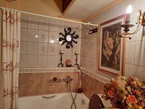 a bathroom with a tub and a clock on the wall at Δάσος ΜΕ ΠΛΑΤΑΝΙΑ in Agios Dimitrios