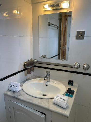 a bathroom with a sink and a mirror at Sost Embassy Hotel By Zeez in Khudābād