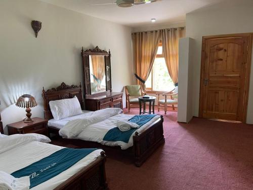 a hotel room with two beds and a mirror at Sost Embassy Hotel By Zeez in Khudābād