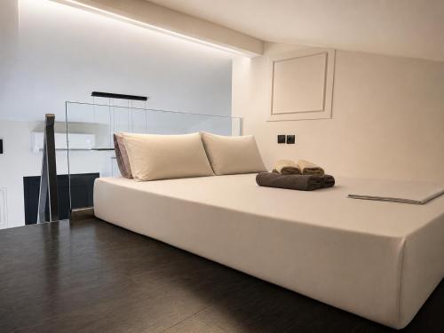 a large white bed in a room with a laptop at L'aTTIQUE in Kastanéa