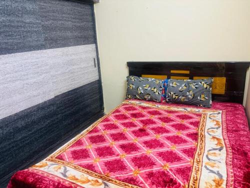 a bedroom with a bed with a pink comforter and pillows at Lara Homestay 2bhk in Secunderabad