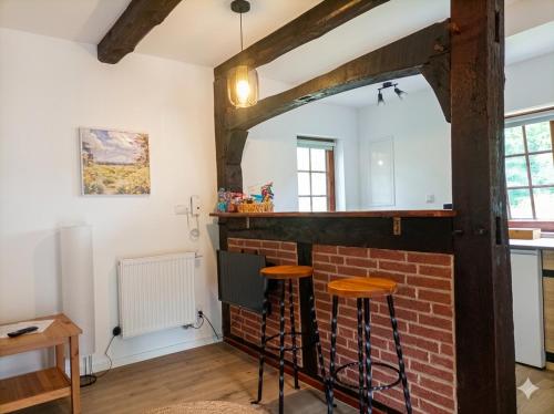 a kitchen with a brick wall and two stools at The Red House in Celle