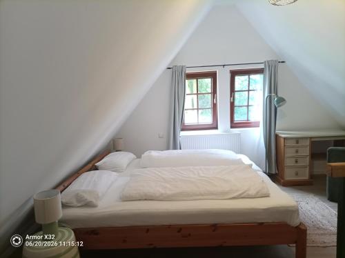 a bedroom with a bed and a staircase with windows at The Red House in Celle