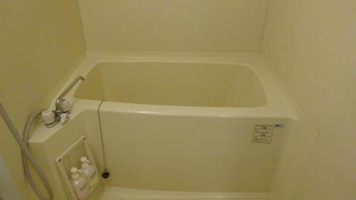 a white bath tub in a corner of a bathroom at Hotel Kinu in Nikko