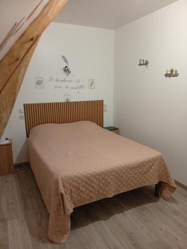 a bedroom with a bed in a white room at Chambre familiale in Voutré