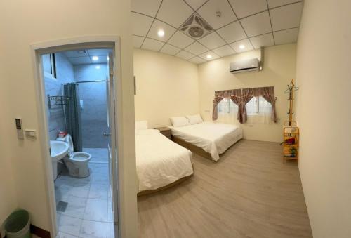 a small room with two beds and a bathroom at 蘭姐的民宿 in Taitung City