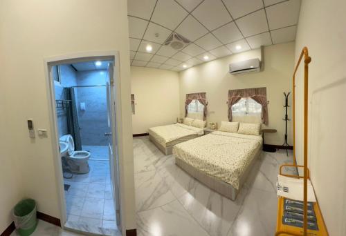 a bedroom with two beds and a bathroom at 蘭姐的民宿 in Taitung City