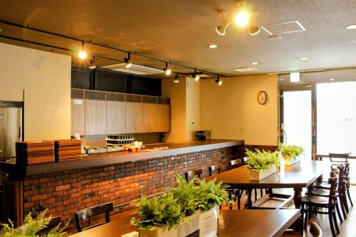 a restaurant with tables and chairs and a kitchen at APA Hotel Komatsu in Komatsu