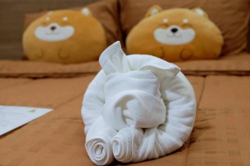 two stuffed teddy bears are sitting on a bed at Christella Hotel Laemchabang in Si Racha