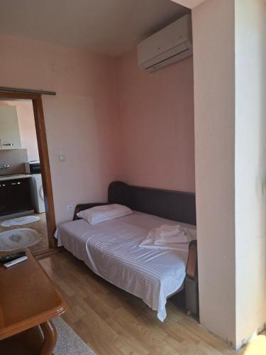 a small bedroom with a bed and a table at Apartmani Lazić No 4 in Gracanica