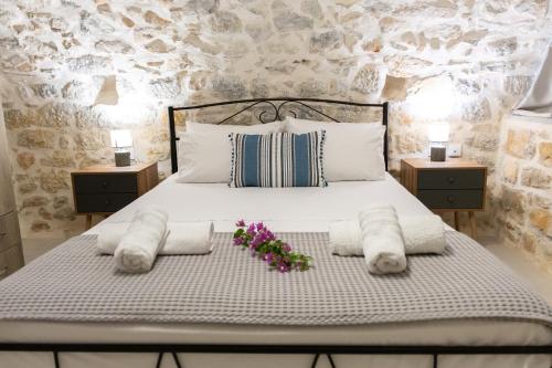 a bedroom with a bed with towels and flowers on it at Mainotti's house in Areopoli