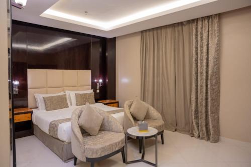 a hotel room with a bed and two chairs at Al Muhaidb Residence Al Takhasossi 2 - Economic in Riyadh