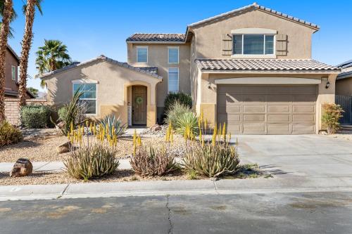 a house with a garage and palm trees at Casa Whimsy in Indio