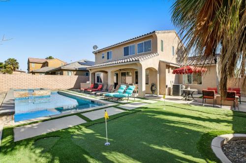 a house with a yard with a putting green at Casa Whimsy in Indio