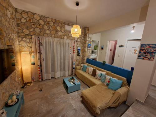 a living room with a couch and a stone wall at Korina's house in Loutsa