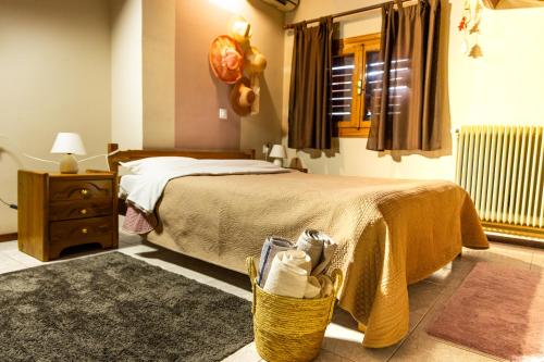 a bedroom with a bed and a basket of shoes at Pool house Axiothea in Neméa