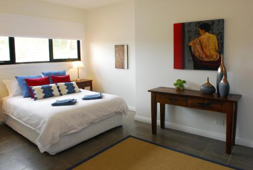a bedroom with a bed and a table and a painting at The Ridge Gloucester in Gloucester