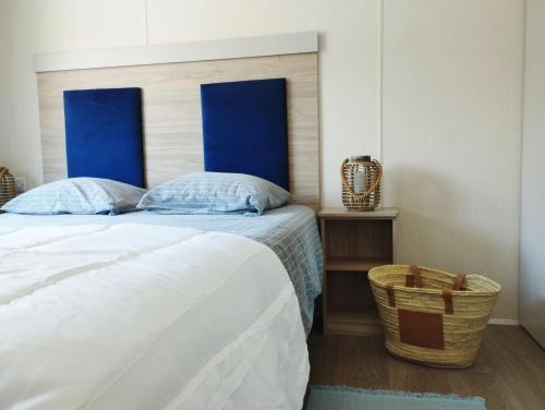 a bedroom with a bed with blue pillows and a basket at The Hillside Lodge in Pizarra