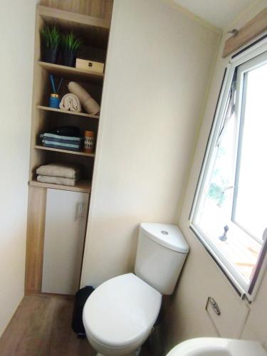 a small bathroom with a toilet and a window at The Hillside Lodge in Pizarra