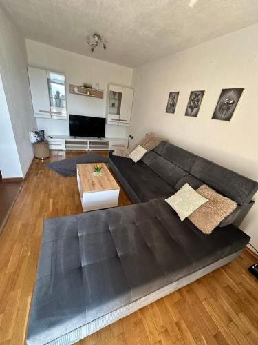 a living room with a black couch and a table at Апартамент “Djanina 2” in Sandanski