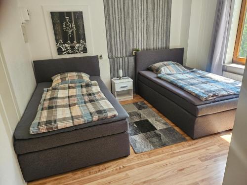 two beds in a living room with a bed and a mattress at Ferienapartment Waldhaus in Marsberg