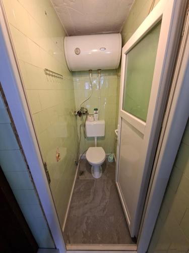 a small bathroom with a toilet and a shower at Roof - Holiday Home in Gjakove