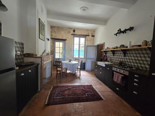 a kitchen with a table in the middle of it at Maison centre historique in Lectoure