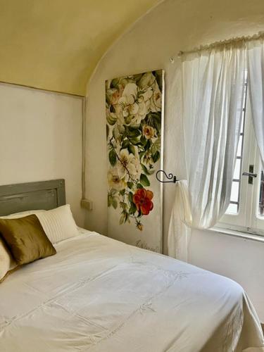 a bedroom with a bed with a flower picture on the wall at Historic Center Cottage Style Apartment in Pontremoli