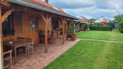a house with a patio with a table and a lawn at Mura Vendégház in Murakeresztúr