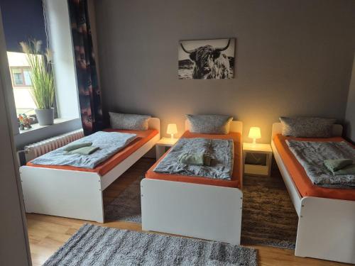 two beds in a room with a bull on the wall at Flensburg City 4 1 in Flensburg