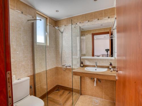 a bathroom with a shower and a toilet and a sink at Kochylari Apartments in Kefalos