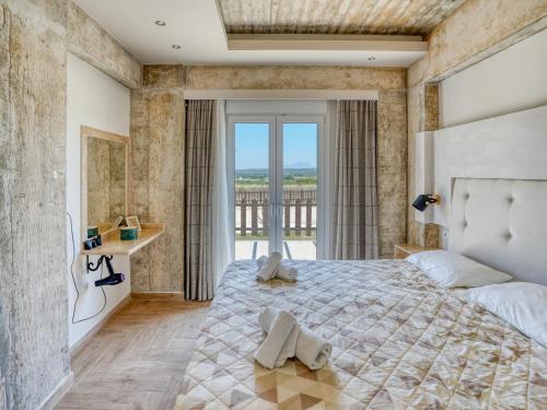 a bedroom with a large bed and a large window at Kochylari Apartments in Kefalos
