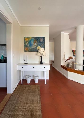 a room with a white desk with a lamp on it at Soltroia Housefeelings in Troia