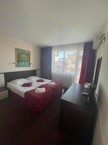a hotel room with a bed and a desk at Peshev Family Hotel Nesebar in Nesebar