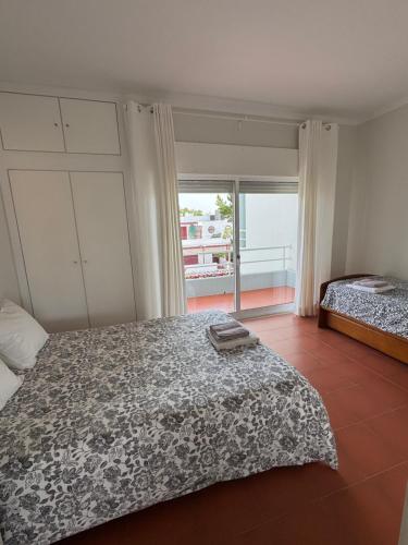 a bedroom with two beds and a balcony at Soltroia Housefeelings in Troia