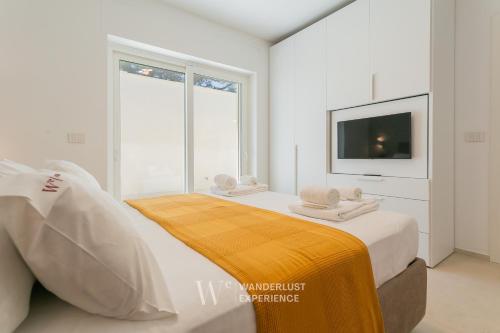 a white bedroom with a large bed with a tv at Wanderlust Experience Villa Milly in Giovinazzo